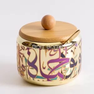 "Elegant gold sugar jar with Arabic calligraphy design, bamboo lid, and golden spoon — modern decorative container for sugar or condiments from Bait Baitk."